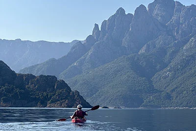 Photo de Kayak et vue sur la mer de corse avec les montagnes dans le fond
